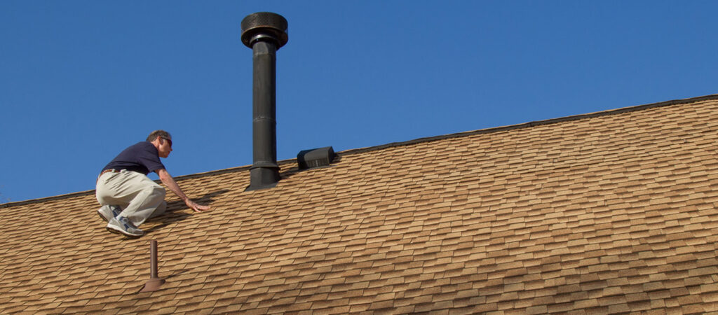 A man doing maintenance on his roof in southern Oregon