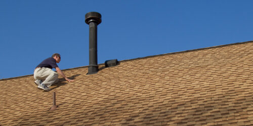 A man doing maintenance on his roof in southern Oregon
