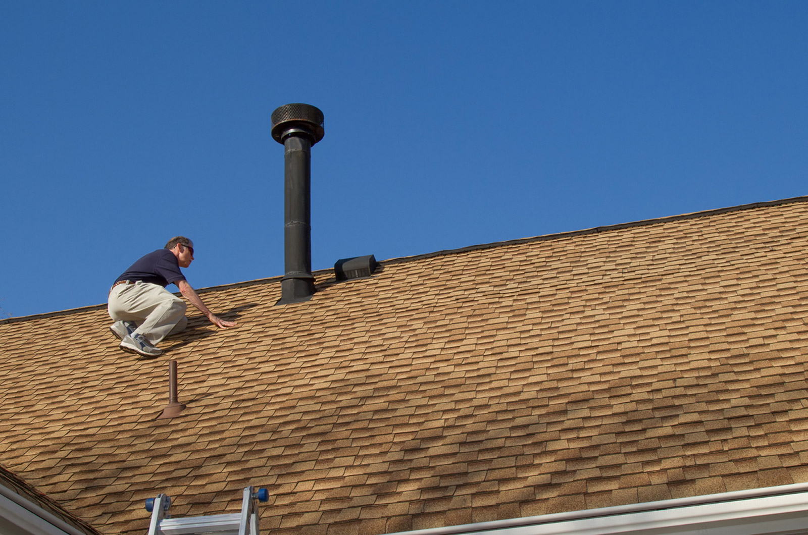 A man doing maintenance on his roof in southern Oregon