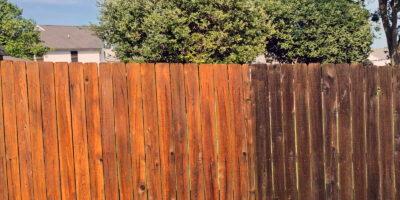 A cedar fence in Southern Oregon with half of it washed and half dirty