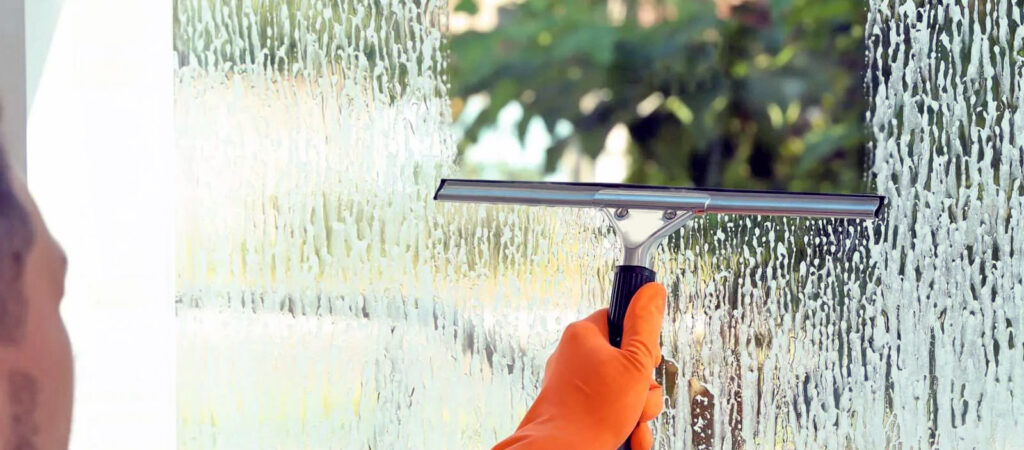 A professional cleaning a window in Southern Oregon