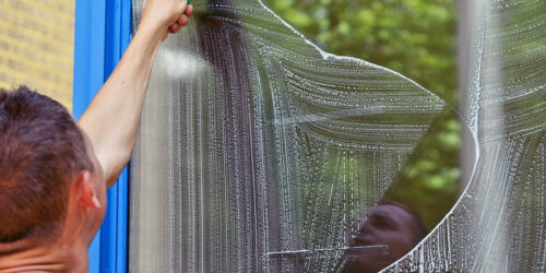 A man cleaning a window and removing streaks